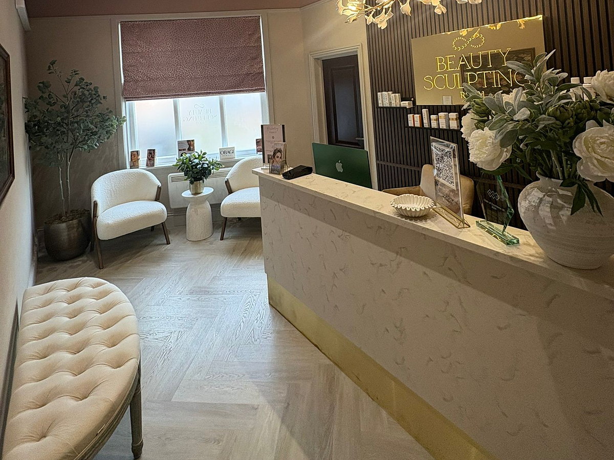 The white marble-effect reception desk with a brass plinth that MSO made for Beauty Sculpting Room in Broadstone