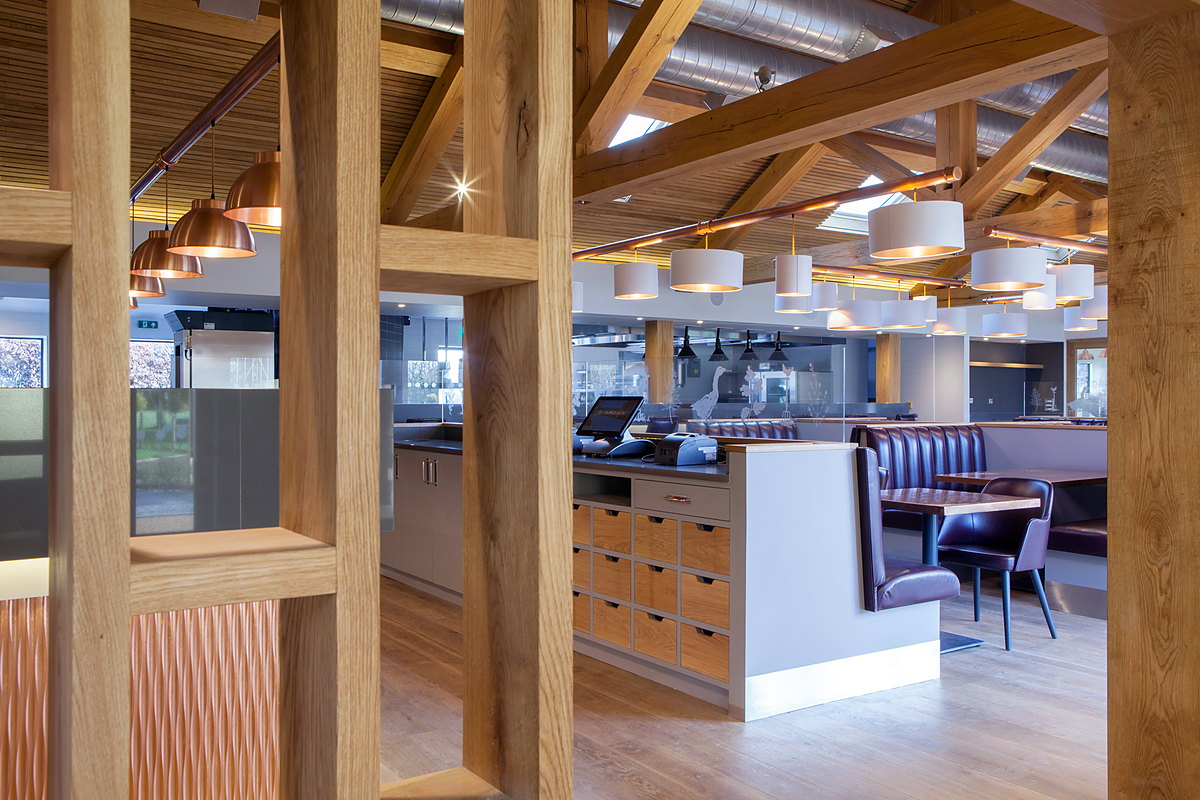 Oak-framed screens dividing the long dining room of The Kitchen at Chewton Glen