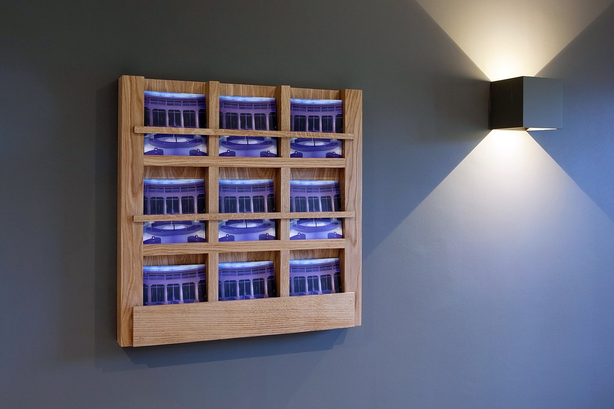 A lit oak wine rack mounted on the wall at The Kitchen, Chewton Glen