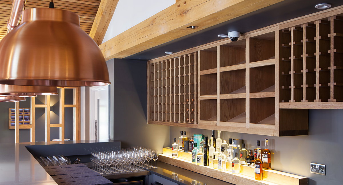 Oak back-bar with wine-rack joinery and copper pendant lights