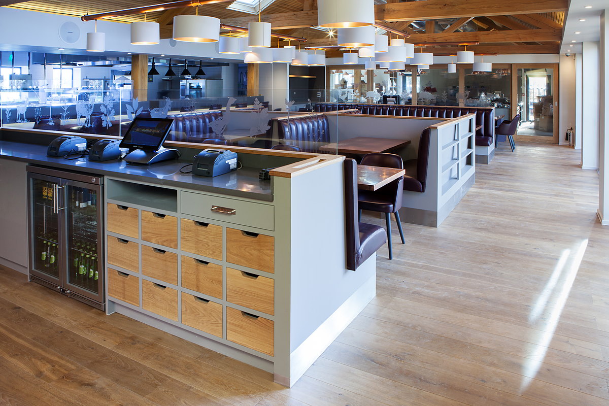 The servery with oak drawer banks and leather booths at The Kitchen, Chewton Glen