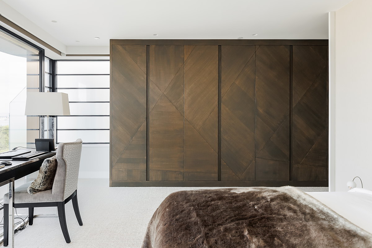 A wall of book-matched chevron walnut doors