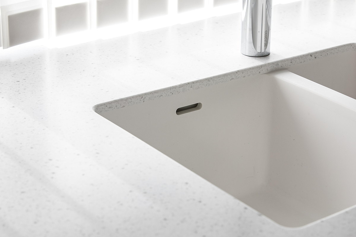 A seamless white undermount sink moulded into an alpine-white solid-surface worktop