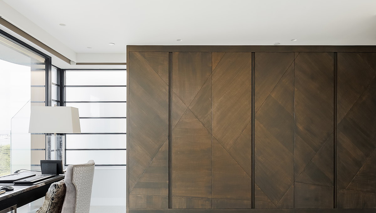 A fitted run of full-height doors in dark timber veneer, laid in a chevron pattern