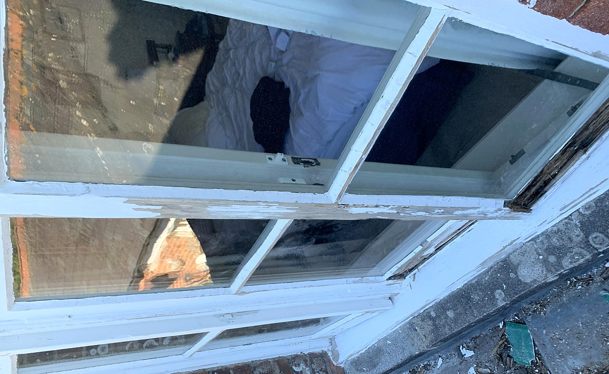 A timber sash window being restored and draught-proofed in situ