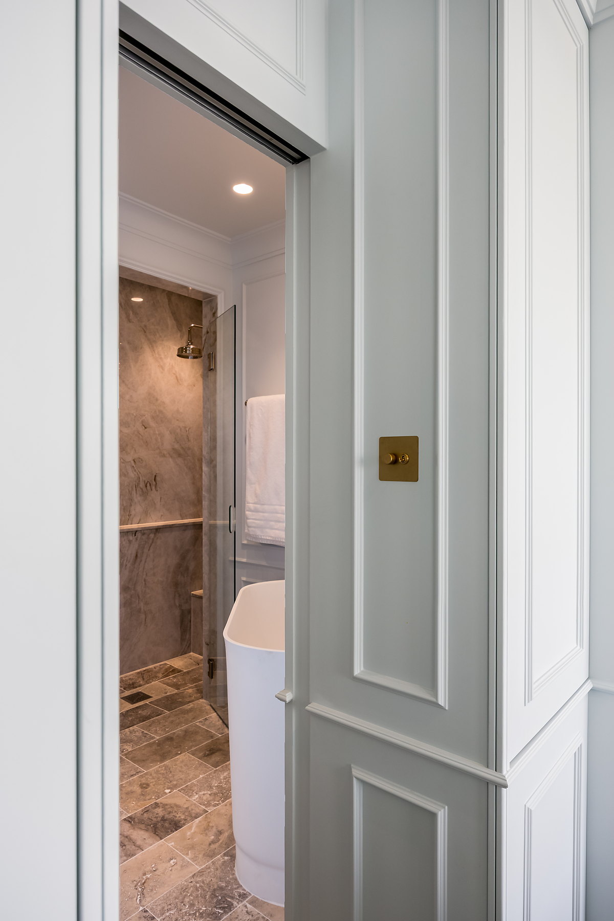 Jib door concealed in a panelled wall leading to an ensuite