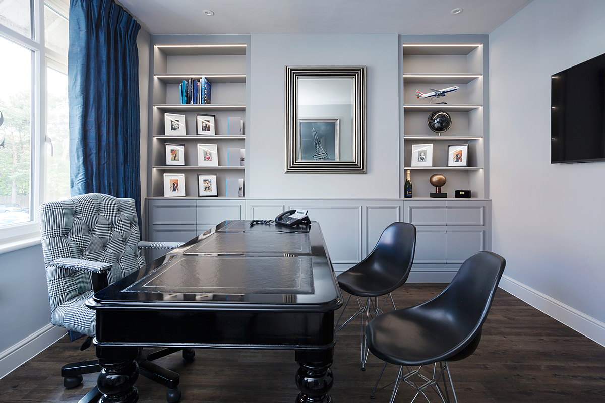A panelled study with fitted shelving and a mirror