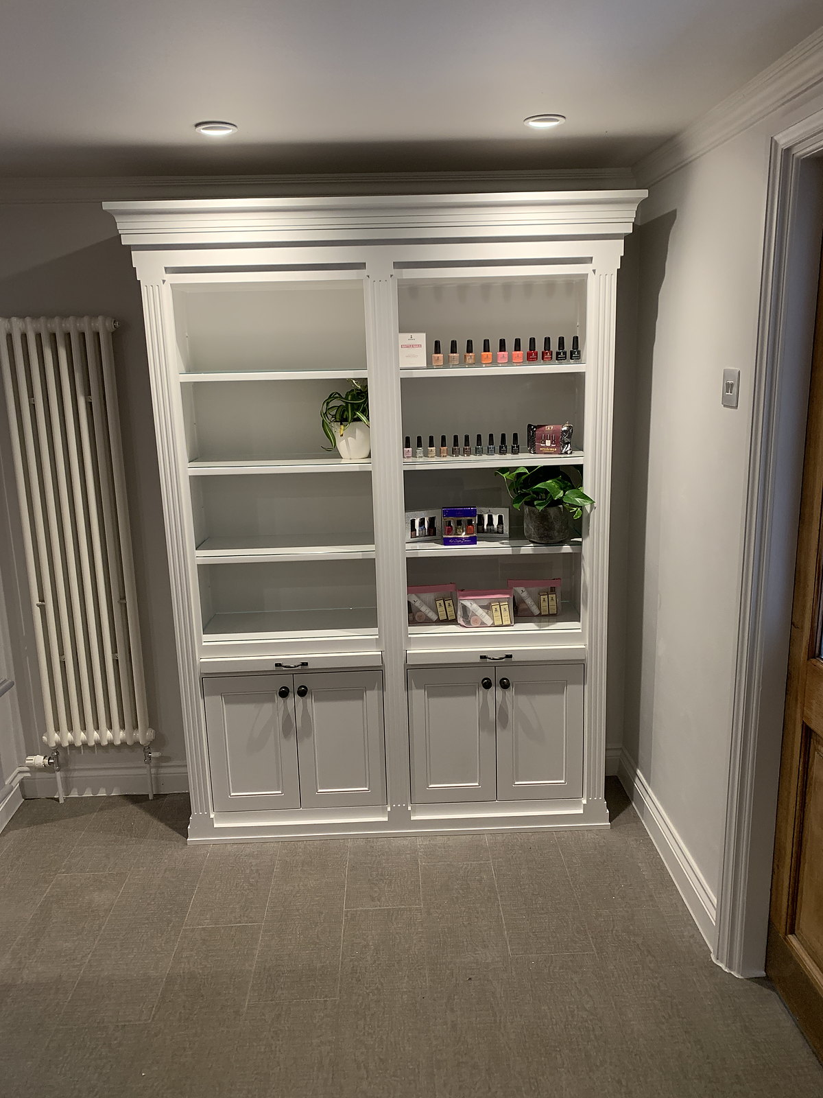 A display cabinet at the Lygon Spa: open shelves of nail polishes and spa products under a moulded cornice