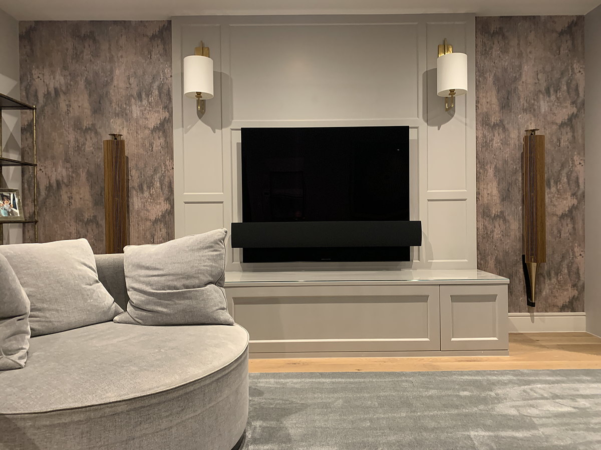 A media wall with a marble-lined recess and fitted cabinetry