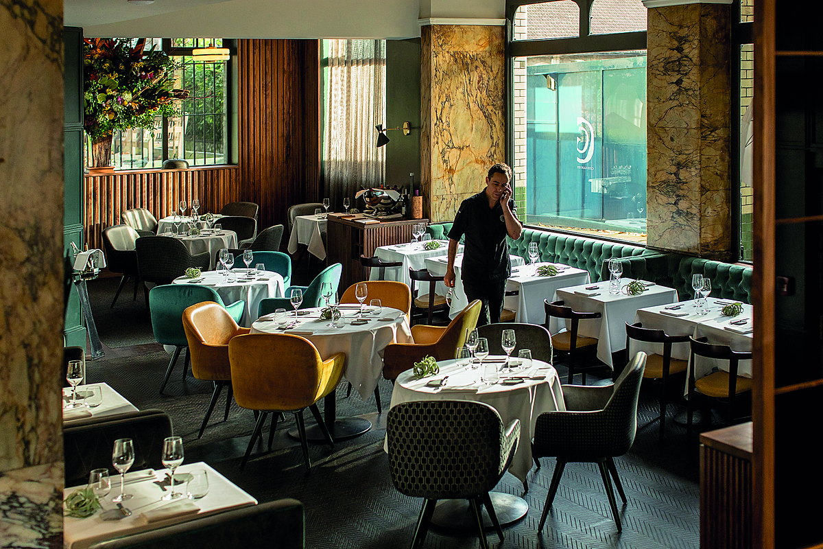 A restaurant fitted out by MSO with green velvet banquettes and marble columns